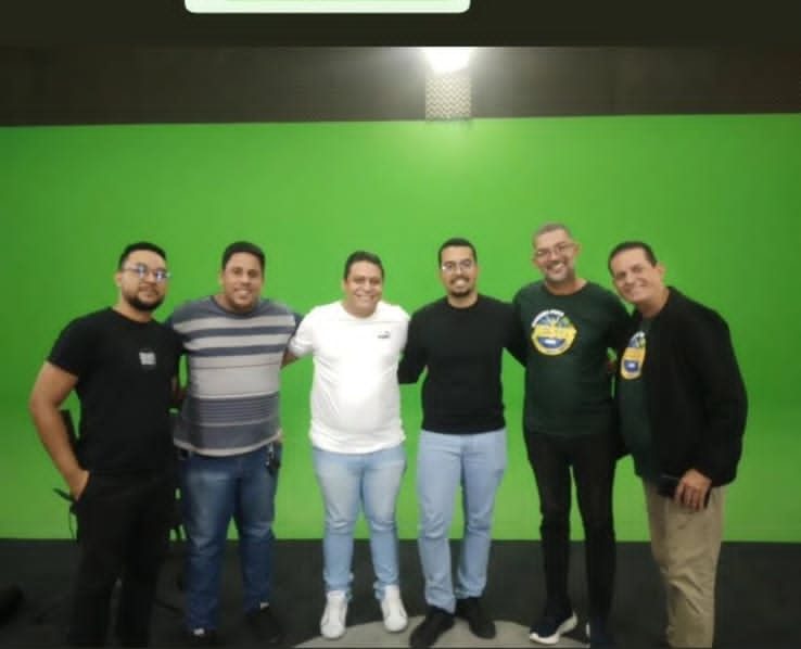 Seis pessoas em frente a um fundo verde de estúdio